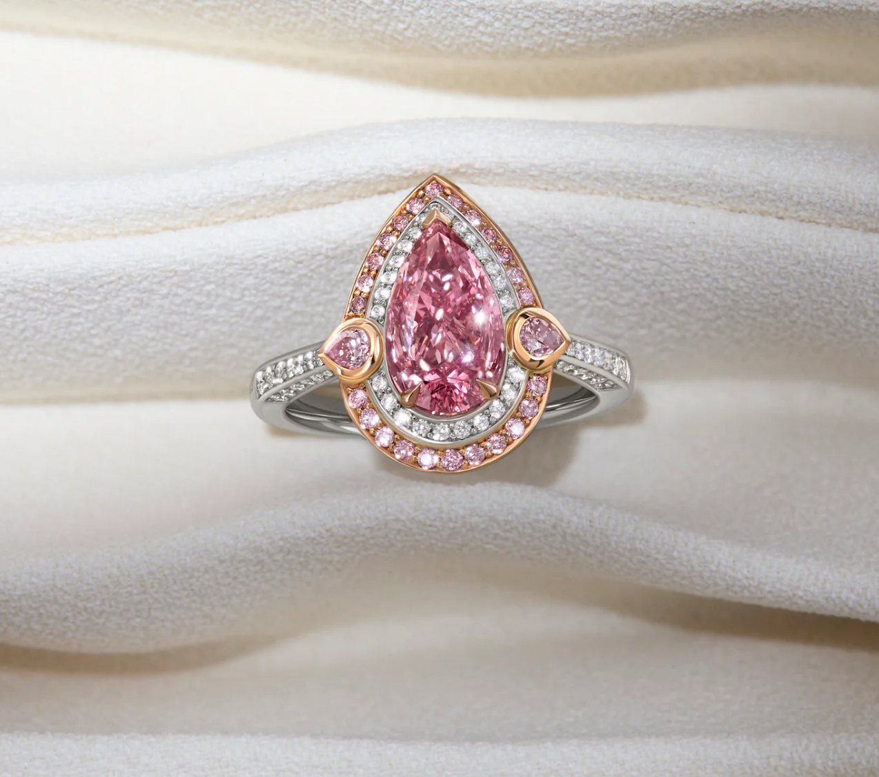 A ring with a large pear-shaped pink diamond at its centre, surrounded by a double halo of white and pink diamonds.