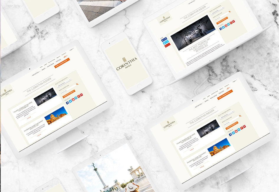 The Corinthia Hotels website page displayed on multiple devices, sat on a white marble table